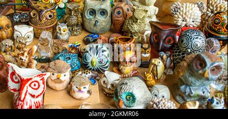 Eine große Auswahl an Miniatureulen aus Keramik, Glas in verschiedenen Formen, Farben und Gemälden auf dem Flohmarkt Stockfoto