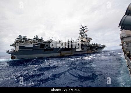 210529-N-JW440-2107 PHILIPPINE SEA (29. Mai 2021) der Flugzeugträger USS Ronald Reagan (CVN 76) der Nimitz-Klasse fliegt neben dem Lenkraketen-Kreuzer USS Shiloh (CG 67) der Ticonderoga-Klasse. Shiloh ist dem Kommandanten der Task Force 70/Carrier Strike Group 5 angeschlossen, der laufende Operationen zur Unterstützung eines freien und offenen Indo-Pazifik-Raums durchführt. Stockfoto