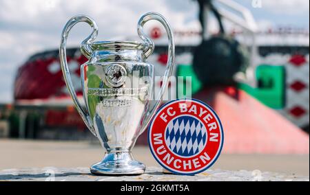 14. Juni 2021 München, Deutschland. Das Emblem des FC Bayern München und des UEFA Champions League Cups vor dem Hintergrund eines modernen Sta Stockfoto
