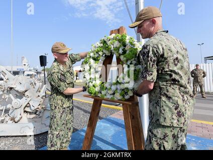 CAMP LEMONNIER, Dschibuti (31. Mai 2021) - Camp Lemonnier, Kommandant des Offiziers der US-Marine, Kapitän Kyle Schuman und sein Nachfolger, Kapitän David Faehnle, überreichen einen Kranz während der Gedenkfeierlichkeiten, die am 31. Mai 2021 in Camp Lemonnier zu Ehren der gefallenen Dienstmitglieder des Landes abgehalten werden. Stockfoto