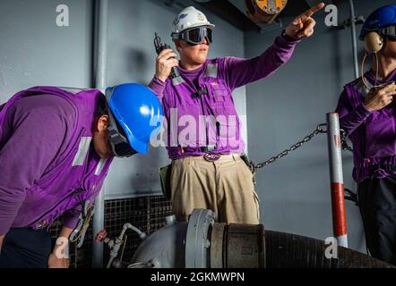 210601-N-NY362-1080 PHILIPPINE SEA (1. Juni 2021) Joshua Hinck, Chief Aviation Boatswain, aus Holyoke, Colorado, leitet Seeleute an Bord des einzigen vorwärts eingesetzten Flugzeugträgers der US-Marine, USS Ronald Reagan (CVN 76), während einer Entwicklung der Betankung auf See. Ronald Reagan, das Flaggschiff der Carrier Strike Group 5, stellt eine kampfbereite Truppe bereit, die die Vereinigten Staaten sowie die kollektiven maritimen Interessen ihrer Verbündeten und Partner in der Indo-Pazifik-Region schützt und verteidigt. Stockfoto