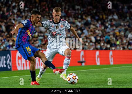 SPANIEN, FUSSBALL, CHAMPIONS LEAGUE, FC BARCELONA GEGEN FC BAYERN MÜNCHEN. FC Bayrcelona (16) Pedri siegt mit (6) Joshua Kimmich beim Champions-League-Gruppenspiel zwischen dem FC Barcelona und dem FC Bayern München am 14. September 2021 im Camp Nou, Barcelona, Spanien. © Joan Gosa 2021 Stockfoto