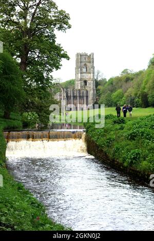 Menschen, die am De Gray's Walk auf dem River Skell in der Fountains Abbey in der Nähe von Ripon in North Yorkshire, England, Großbritannien, vorbeigehen. Stockfoto