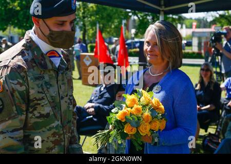 Sgt. Kelly Harper, 7. Armeeausbildungskommando, überreicht Beth Hilbert, Frau von U.S. Army Brig, einen Blumenstrauß. General Joseph E. Hilbert, der ankommende Kommandant des 7. ATC, während der 7. ATC-Befehlswechselzeremonie auf dem Paradefeld in der Tower Barracks, Deutschland, am 2. Juni 2021. Hilbert, der zuvor beim 7. ATC als Kommandant der Operations Group für das Joint Multinal Readiness Center in Hohenfels, Deutschland, gedient hatte, kehrte nach Bayern zurück, um das Kommando über den 7. ATC zu übernehmen. Stockfoto