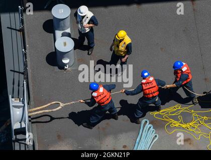 ATLANTISCHER OZEAN (2. Juni 2021) Segler der Decksabteilung hegen sich um eine Schleppleine, um an Bord der Expeditionary Sea Base USS Hershel „Woody“ Williams (ESB 4) im Atlantischen Ozean in den Hafen einzuziehen, 2. Juni 2021. Hershel „Woody“ Williams ist im geplanten Einsatzgebiet der Sechsten Flotte der USA zur Unterstützung der nationalen Interessen und der Sicherheit der USA in Europa und Afrika im Einsatz. Stockfoto