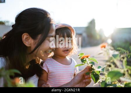 Mutter und Tochter pflücken ziemlich bunte Blumen im Park Stockfoto