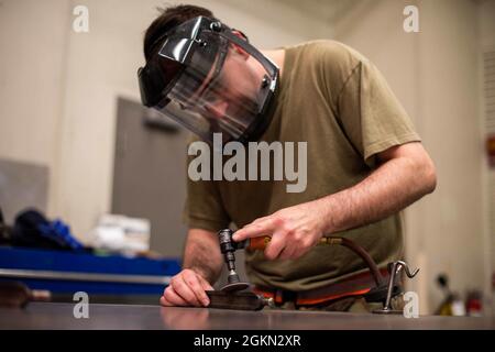 Senior Airman Anthony Konold, Mitarbeiter der 22. Maintenance Squadron Metals Technology, mischt Unvollkommenheiten an einem Bremsschlüssel mit einer Schleifmaschine 2. Juni 2021 auf der McConnell Air Force Base, Kansas. Metalltechnologie Airmen repariert Ausrüstung von Luft- und Raumfahrtgeräten bis hin zu Flugzeugen und Bodenfahrzeugen. Stockfoto