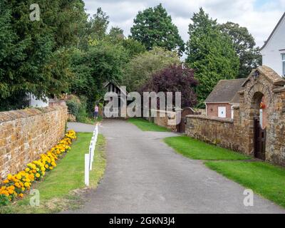 Annäherung an die Kirche St. Luke im Dorf Duston, Northampton, Großbritannien Stockfoto