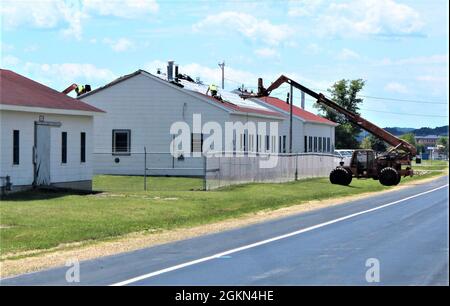 Bauunternehmer ersetzen das Dach am 2. Juni 2021 in Gebäude 1261 im Kantonspark in Fort McCoy, Wisconsin. Zwei Bauunternehmer ersetzen das Dach an mehr als 20 Gebäuden bei der Installation. Nach Angaben der Direktion für Öffentliche Arbeiten, der für die Koordinierung des Baus zuständigen Behörde, werden die Arbeiten bis in den Sommer und bis in den Herbst dauern. Stockfoto