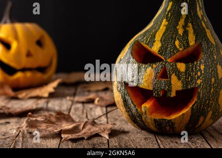 Halloween grüne Kürbisse auf Holztisch und schwarzem Hintergrund Stockfoto