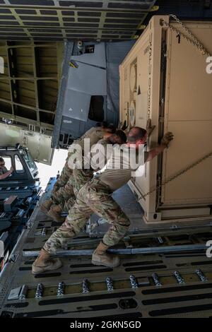 Flieger der 635. Materialerhaltungsgruppe schieben palettierte Ladung auf eine Dover Air Force Base C-5M Super Galaxy während einer großen Command Service Tail Trainer Übung auf der Holloman AFB, New Mexico, 2. Juni 2021. Loadmasters vom 9. Airlift Squadron koordinierten Fracht mit dem 49. Flügel des Air Education and Training Command und den 635. MMG Airmen des Air Force Materials Command, um die 10-tägige MSTT abzuschließen. Während des Trainings luden und entladen Airmen 320,085 Pfund Fracht, einschließlich palettierter Fracht, Bodenausrüstung des Flugzeugs, eines Tankwagens und eines K-Laders. Stockfoto