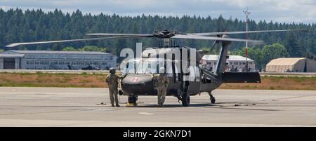 Spc. Hogan McCoy und SPC. Joshua Barajas, UH-60 Blackhawk Helikopterbesatzungsleiter, die dem 2-158 Assault Helicopter Bataillon, der 16. Combat Aviation Brigade, zugewiesen sind, führen am 3. Juni 2021 Vorflugkontrollen an der Joint Base Lewis McChord, Washington, durch. Die Crew-Chefs führen vor, während und nach dem Flugbetrieb Wartung, Sicherheit und Schießerei durch. Stockfoto