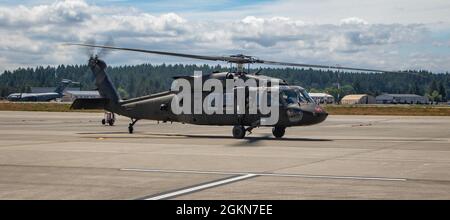 Spc. Hogan McCoy, ein UH-60-Chef der Blackhawk-Hubschrauber-Crew, der dem 2-158 Assault Helicopter Bataillon, der 16. Kampfluftfahrtbrigade, zugewiesen wurde, stellt sich während eines Taxis am Joint Base Lewis McChord, Washington, am 3. Juni 2021 aus seinem Sitz. Die Crew-Chefs führen vor, während und nach dem Flugbetrieb Wartung, Sicherheit und Schießerei durch. Stockfoto
