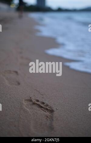 Menschliche Fußabdrücke (und die Person selbst) am unberührten Strand Stockfoto