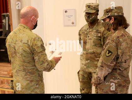 Der australische Generalmajor der Armee, General Christopher A. Field, der stellvertretende Generalkommandant der US-Armee, spricht mit dem scheidenden Kommandanten des regionalen Vertragszentrums Kuwait, LT. Col. Jamarcus A. Brooks, und dem neuen Kommandanten LT. Col. Melody L. Varner kurz vor dem 4. Juni 2021, dem Befehlswechsel des Zentrums im Lager Arifjan, Kuwait, Hauptkapelle. Der Befehlswechsel wurde als eine Veranstaltung im Freien mit Abdeckungen und Grüßen behandelt, die aufgrund der extremen Hitze in Innenräumen abgehalten wurde. Stockfoto