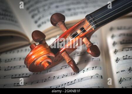 Detail eines Geigengriffs, der auf einer Partitur ruht Stockfoto