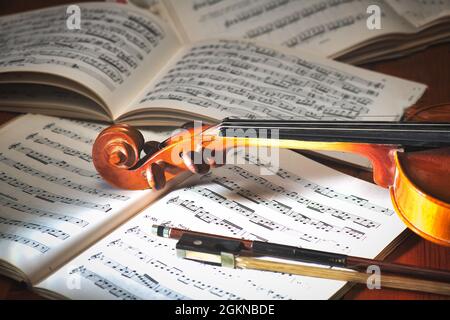 Geige mit Bogen auf Notenbuch Stockfoto