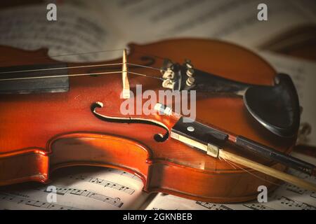 Violine und Bogen auf Notenblättern Stockfoto