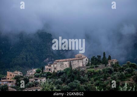 Wolken in den Hügeln hinter der Kirche Sant Joan, Deià, Mallorca, Spanien Stockfoto