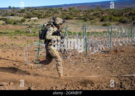 Soldaten, die der 3. Squadron, dem 4. Kavallerieregiment und dem 29. Brigadeingenieur Bataillon, der 3. Infanteriebrigade Combat Team, der 25. Infanteriedivision zugewiesen sind, führen eine Koordinationsübung zur Brandunterstützung durch, unterstützt von den Apache Attack Helicopters AH-64, die der 25. Luftwaffenbrigade, der 25. Infanteriedivision Hawaii am 4. Juni 2021. Diese Übung ermöglichte es Führungskräften auf Unternehmensebene und darunter, ein tieferes Verständnis dafür zu erlangen, wie verschiedene Vermögenswerte während eines großen, bewussten Betriebs ordnungsgemäß implementiert werden können. Stockfoto