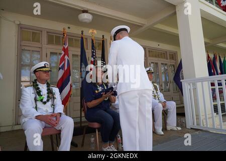 Chief David E. Wilson und Chief Joseph D. Rogers überreicht Caroline Burton während der Zeremonie des Befehlswechsels von Capt. Burton in Pearl Harbor, Hawaii (4. Juni 2021) eine gefaltete Flagge. PHNSY & IMF ist eine Feldtätigkeit von NAVSEA und ein regionales Wartungszentrum für die Oberflächenschiffe und U-Boote der Marine aus einer Hand. Stockfoto