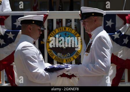 Chief David E. Wilson und Chief Joseph D. Rogers führen während der Zeremonie des Kommandowechsels von Capt. Burton in Pearl Harbor, Hawaii (4. Juni 2021) eine Faltung der Flagge vor. PHNSY & IMF ist eine Feldtätigkeit von NAVSEA und ein regionales Wartungszentrum für die Oberflächenschiffe und U-Boote der Marine aus einer Hand. Stockfoto