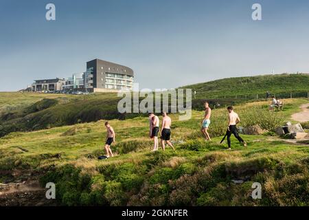 Eine Gruppe junger männlicher Urlauber, die sich darauf vorbereiten, am Towan Head in Newquay in Cornwall von den Felsen zu springen. Stockfoto