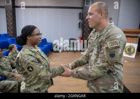 US Army Staff Sgt. Chiara Fleming, Leiterin der Dekontaminationsgruppe, 318. Chemical Biological Radiological and Nuclear Defense Company, Task Force Spartan, erhält eine Münze von Sgt. Erstklassig. Peter Gault, Platoon Sergeant for the Hazard Assessment Platoon, 318. CBRN, Task Force Spartan, für ihr Engagement und ihre Professionalität im Joint Training Center, Jordanien, 05. Juni 2021. Eine Münze ist eine Möglichkeit für die Führungskräfte, einem Soldaten ihre Wertschätzung für eine hervorragende Arbeit zu zeigen. Stockfoto