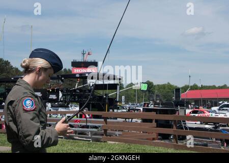 Oberleutnant Samanda McGiffin, Mitglied der 164. Airlift Squadron am 179. Airlift Wing, hält am 5. Juni 2021 ein Radio, um mit der Crew an Bord einer C-130 auf dem Mid-Ohio Sports Car Course zu kommunizieren. Der 179. Airlift Wing wurde von Mid-Ohio beauftragt, während der National Anthem eine C-130 über die Strecke zu fliegen. Stockfoto