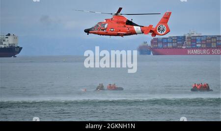 Ein Hubschrauber der US-Küstenwache MH-65 Dolphin schwebt über dem Meer vor der Küste von Seal Beach, Kalifornien, 5. Juni 2021. Die USCG praktizierte die Rettung von Hebern mit Soldaten, die dem 1. Sturmhubschrauber-Bataillon der California Army National Guard, dem 140th Aviation Regiment, zugewiesen wurden. Stockfoto