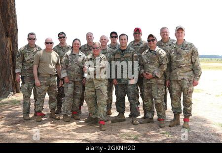 Das Jumpmaster-Team der US Army Civil Affairs and Psychological Operations Command (Airborne) posiert für ein Gruppenfoto von links nach rechts, Maj. Mark D. Montgomery, Maj. Troy M. Royko, Maj. Joshua M. Luedtke, LT. Col. Lauren R. Sharpless, Maj. Johsua A. Cox, Maj. Amber M. Hansen, LT. Col. Stephen M. Cowne, Jr., Maj. Sean P. Howen, Capt. Ignacio Rios, Sgt. Benjamin J. Van Buren, Meister Sgt. Matthew G. Meyers, Chief Warrant Officer 5 (CW5) Michael A. Rich und Col. Kevin M. Myers, nachdem sie nichttaktische Flugoperationen mit einem Hubschrauber der Serie UH-60 Black Hawk in der Fallzone Saint Mere Eglise in Fort durchgeführt hatten Stockfoto