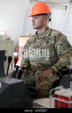 Sgt. Hector Gonzalez, eine Werkstatt für Angriffshubschrauber mit Alpha Company, 1. Angriffsbataillon, 82. Kampfluftfahrtbrigade, betreibt einen Spyder-Lift, um Hubschrauberblätter von einem AH-64E Apache-Angriffshubschrauber auf der Luftwaffenbasis Erbil, Irak, zu entfernen. Stockfoto