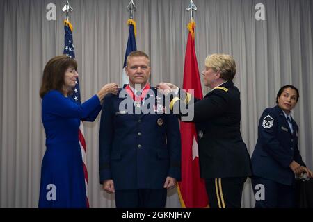 Mark Gaul wird von seiner Frau (links) und Maj. General Tracey Noris, dem Adjutanten General der texanischen Nationalgarde, während seiner Beförderung nach Brig mit Sternen angestachelt. Gen. Stockfoto