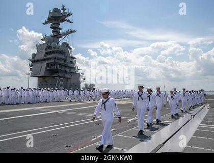 Matrosen, die der USS Gerald R. Ford (CVN 78) zugewiesen wurden, bemunden die Schienen zu Ehren des 79. Jahrestages der Schlacht von Midway, als sie die Naval Station Norfolk verlassen, am 7. Juni 2021. Die Schlacht von Midway vom 4. Bis 7. Juni 1942 war ein epischer Zusammenstoß zwischen der US-Marine und der kaiserlichen japanischen Marine, wo der entscheidende Sieg der Marine den Zweiten Weltkrieg im Pazifik effektiv umdrehte. Das Schiff verlässt Norfolk in Vorbereitung auf Full Ship Shock Trials. Die US Navy führt Schockversuche an neuen Schiffsdesigns mit Live-Sprengstoffen durch, um zu bestätigen, dass unsere Kriegsschiffe auch weiterhin anspruchsvolle Missionsziele erfüllen können Stockfoto