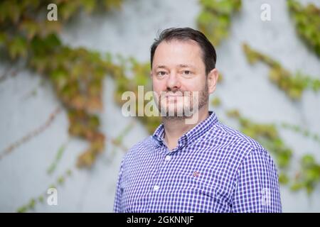 Berlin, Deutschland. September 2021. Clemens Krauss, Künstler, blickt vor einem Interviewtermin mit der Deutschen Presse-Agentur im Berliner Haus am Lützowplatz in die Kamera des Fotografen. Die österreichische Künstlerin ist auch Psychoanalytikerin. Für seine neue Ausstellung 'Massen/ Masses' in Berlin plant er eine Performance mit Gruppensitzungen mit bis zu zwölf Teilnehmern. (To dpa: 'The artificial skin of Clemens Krauss - Berlin Art Week Begins') Quelle: Christoph Soeder/dpa/Alamy Live News Stockfoto