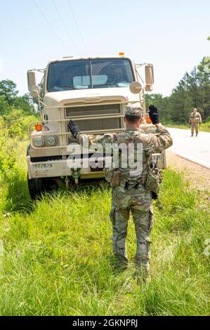 Personal Sgt. James Dean, ein Beobachtertrainer/Trainer mit 1. Bataillon, 33. Brigade-Ingenieur-Bataillon, 181. Multifunktionale Trainingsbrigade, Bodenführer eines M915A5 Line-Haul-Traktorwagens aus einem Graben an einer Straße 8. Juni 2021, auf Fort McCoy, Wis. die Fahrzeuge mussten sicher aus dem Graben gefahren werden, ohne den Kipppunktwinkel jedes Lkw zu beeinträchtigen. Stockfoto