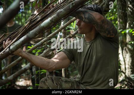 US Air Force Tech Sgt. Casey Carter, ein Spezialist für Überleben, Evasion, Widerstand und Flucht mit 18. Operational Support Squadron, unterrichtet Marines with Explosive Ordnance Disposal (EOD) Company, 9. Engineer Support Bataillon, 3d Marine Logistics Group (MLG), Jungle Survival Techniques on Camp Gonsalves, Okinawa, Japan, 8. Juni 2021. EOD Marines unterstützen Expeditionary Advanced Base Operations durch Üben von Überlebensmethoden in Gebieten, in denen logistische Unterstützung möglicherweise nicht zugänglich ist, aber der Abschluss der Mission immer noch Priorität hat. 3d MLG mit Sitz in Okinawa, Japan, ist eine nach vorne eingesetzte Kampfuni Stockfoto