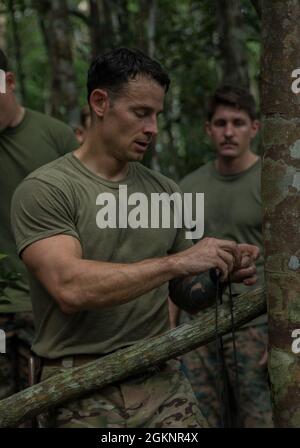 US Air Force Tech Sgt. Casey Carter, ein Spezialist für Überleben, Evasion, Widerstand und Flucht mit 18. Operational Support Squadron, unterrichtet Marines with Explosive Ordnance Disposal (EOD) Company, 9. Engineer Support Bataillon, 3d Marine Logistics Group (MLG), Jungle Survival Techniques on Camp Gonsalves, Okinawa, Japan, 8. Juni 2021. Während des Trainings bereitete sich EOD Marines darauf vor, Expeditionary Advanced Base Operations durch Üben von Überlebensmethoden in Gebieten zu unterstützen, in denen logistische Unterstützung möglicherweise nicht verfügbar ist. 3d MLG mit Sitz in Okinawa, Japan, ist eine nach vorne eingesetzte Kampfeinheit, die dient Stockfoto