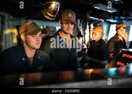 210607-N-TP544-4155 ATLANTISCHER OZEAN (7. Juni 2021) Jason Rennick, ein Mann der 3. Klasse von Boatswain, links, dem amphibischen Sturmschiff USS Bataan (LHD 5) der Wasp-Klasse zugewiesen, beauftragt den Midshipman der 2. Klasse Cole Yung der US Naval Academy mit der Navigation und dem Pilotierung am 7. Juni 2021 an Bord der USS Kearsarge (LHD 3). Kearsarge, Homeported auf der Marinestation Norfolk, ist im Gange für eine Inspektion durch das Board of Inspection and Survey. Stockfoto