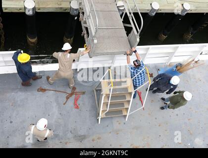 210608-N-OH262-0854 NORFOLK, VA. (8. Juni 2021)--zivile Seeleute, die dem ozeanographischen Surveyschiff des Militärkommandos USNS Bruce C. Heezen (T-AGS 64) zugewiesen wurden, positionieren die Gangway, die von Personal zum Aussteigen des Schiffes verwendet wird, während das Schiff am 8. Juni in die Marinestation Norfolk einfährt. Die Seeleute, die USNS Bruce C. Heezen besetzen, sind bei der beauftragten Betreibergesellschaft Ocean Ships, Inc. Beschäftigt Stockfoto
