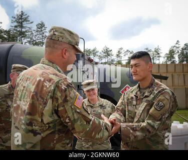 US Army Brig. General Jeffery Copeland, Director of Joint Staff und Assistant Adjutant General, verleiht Pvt. 1. Klasse Chen Li, zugewiesen an Echo Company 1-130. Angriffsbataillon, 449. Kampfluftfahrtbrigade, eine Spitzenmünze in Fort Bragg, N.C., 8. Juni 2021. Copeland besuchte Soldaten der 1-130 ab, die ihre jährliche Ausbildung durchführen. Stockfoto