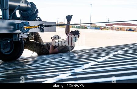 Personal Sgt. John Dittess, Ladermeister der 9. Airlift Squadron, hilft beim Rangieren von Bodenausrüstung von Flugzeugen auf eine Dover Air Force Base C-5M Super Galaxy während eines Major Command Service Tail Trainers auf der Holloman AFB, 8. Juni 2021. Loadmasters vom 9. ALS koordinierte Fracht mit den Luftfahrtscharen vom 49. Flügel des Air Education and Training Command und der 635. Material Maintenance Group des Air Force Materials Command, um die 10-tägige MSTT abzuschließen. Im Laufe des Trainings luden und entladen Airmen 320,085 Pfund Fracht, darunter palettierte Fracht, ALTER, einen Tankwagen und einen K-Lader. Stockfoto