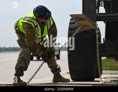 Ein Power Production Airman der 110. Civil Engineer Squadron, Michigan Air National Guard, wickelt eine Kette um einen Gabelstapler am 8. Juni 2021 im Alpena Combat Readiness Training Center (CRTC), Michigan. Die Alpena CRTC ersetzte ihr Luftfahrzeug-Arretsystem, das im Notfall helfen soll, Flugzeuge mit Heckhaken zu stoppen. Stockfoto