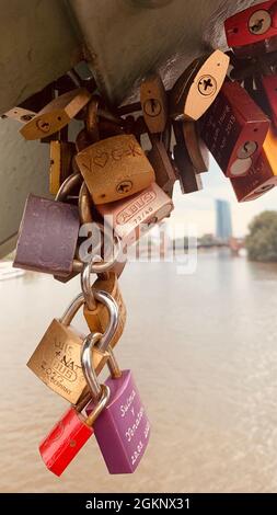 FRANKFURT, DEUTSCHLAND - 23. Jul 2021: Eine vertikale Aufnahme von bunten Liebesschlössern, die an der eisernen Fußgängerbrücke in Frankfurt hängen Stockfoto