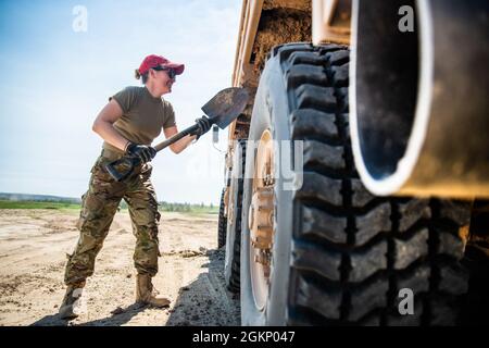 Ein Mitglied des 201st Rapid Engineer Deployable Heavy Operational Repair Squadron Engineers (REDHORSE) 193. Special Operations Wing, Pennsylvania Air National Guard, entfernt gehärtete Trümmer aus einem Stück schwerer Ausrüstung, die zur Unterstützung bei der Umstrukturierung der taktischen Landebahn am 9. Juni 2021 verwendet wird, Camp Guernsey, Wyo. Der taktische Flugstreifen ist entscheidend für das Training der strengen Landebedingungen für die C-130 Hercules-Besatzung und Flugzeuge, die dem 187. Airlift Squadron mit dem 153. Airlift Wing, Wyoming Air National Guard, zugewiesen wurden. Stockfoto