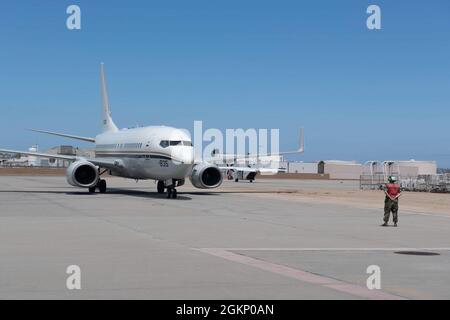 210609-N-SF984-0047 SAN DIEGO (Juni 9,2021) Mate von Aviation Electricians 3. Klasse Simon Town, zugewiesen an die 'Conquistadors' des Fleet Logistics Squadron (VR) 57 signalisiert während des Flugbetriebs einem der C-40 Clippers der Staffel. VR-57 ist ein Navy Reserve-Geschwader, das logistische Unterstützung in der gesamten Flotte bietet. Stockfoto