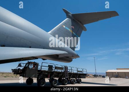 Ein K-Lader wird während eines Major Command Service Tail Trainers auf der Holloman AFB, New Mexico, am 9. Juni 2021 auf eine Dover Air Force Base C-5M Super Galaxy geladen. Loadmasters vom 9. Airlift Squadron koordinierte Fracht mit Airmen vom 49. Flügel und der 635. Materialwartungsgruppe, um das 10-tägige MSTT abzuschließen. Im Laufe des Trainings luden und entladen Airmen 320,085 Pfund Fracht, darunter palettierte Fracht, Bodenausrüstung der Flugzeuge, einen Tankwagen und einen K-Lader. Stockfoto