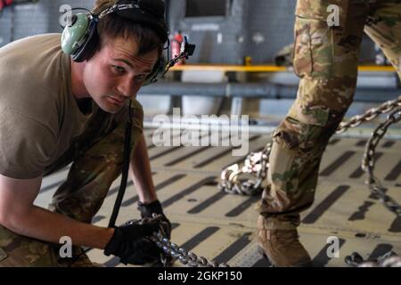 Personal Sgt. John Dittess, Ladermeister der 9th Airlift Squadron, kettet während eines Major Command Service Tail Trainers auf der Holloman AFB am 9. Juni 2021 einen K-Lader an den Laderaum einer Dover Air Force Base C-5M Super Galaxy. Loadmasters vom 9. ALS koordinierte Fracht mit den Luftfahrtscharen vom 49. Flügel des Air Education and Training Command und der 635. Materialwartungsgruppe des Air Force Materials Command, um die 10-tägige MSTT abzuschließen. Im Laufe des Trainings luden und entladen Airmen 320,085 Pfund Fracht, darunter palettierte Fracht, Bodenausrüstung der Flugzeuge, einen Tankwagen und einen K-Lader. Stockfoto