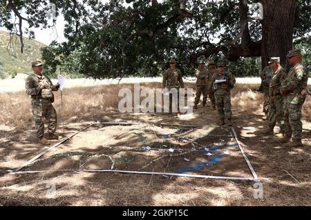 US Army National Guard Sgt. Nicholja Combs der 1. Klasse, Observer, Coach, Trainer, mit der Einsatzgruppe der Nationalgarde der Armee Wolf unterzieht Oberst Randy I. Lau, Kommandeur des Kampfteams der 79. Infanterie-Brigade auf einer Verteidigungslinie der Verlobungsgebiet-Entwicklungsgesellschaft 9. Juni 2021 während der exportierbaren Kampftrainingsfähigkeit 21-01 in Fort Hunter Liggett, Kalifornien. Vor der Hinrichtung von XCTC 21-01 gründeten die 189. Combined Arms Training Brigade, First Army West und ARNG-OGW 24 Trainingswege, um die spezifischen Trainingsziele von Lau zu erreichen. Jede Spur wurde gebaut, um auf die Kampffähigkeiten des 79. IBCT zuzugreifen Stockfoto