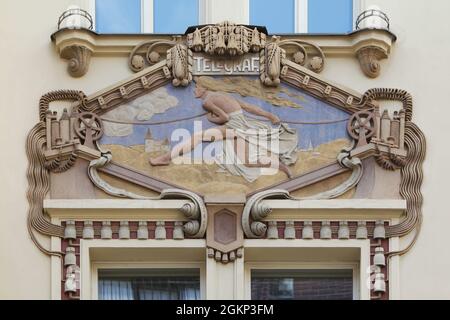 Telegraph im Stuckrelief des Verlags Edvard Beaufort (Beaufortovo nakladatelství) in Nové Město (Neustadt) in Prag, Tschechische Republik. Das vom tschechischen Architekten Osvald Polívka entworfene Jugendstilgebäude wurde von 1907 bis 1910 in der Jungmannova-Straße erbaut. Stockfoto